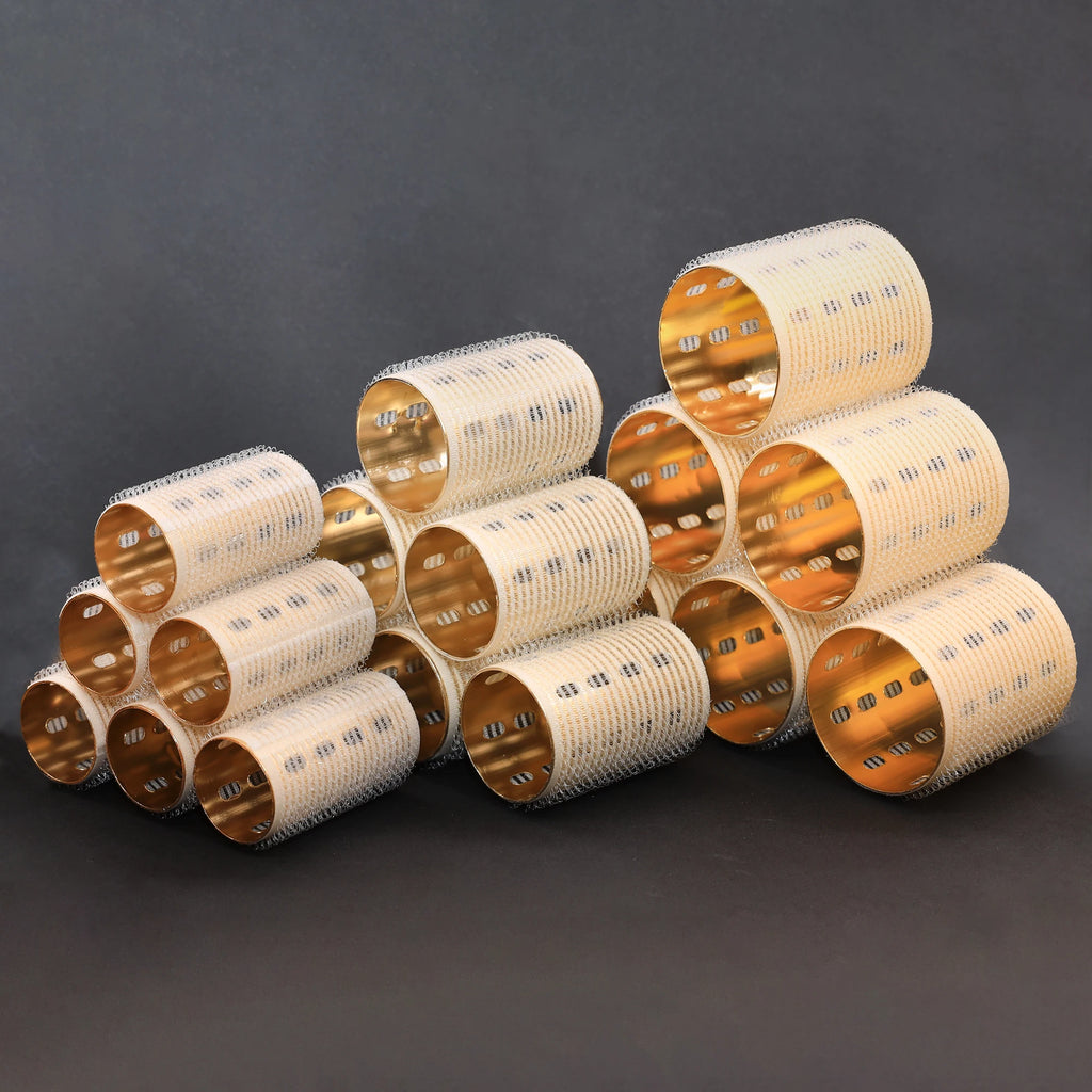 Stack of ceramic thermal hair rollers with gold and beige patterns on a dark background