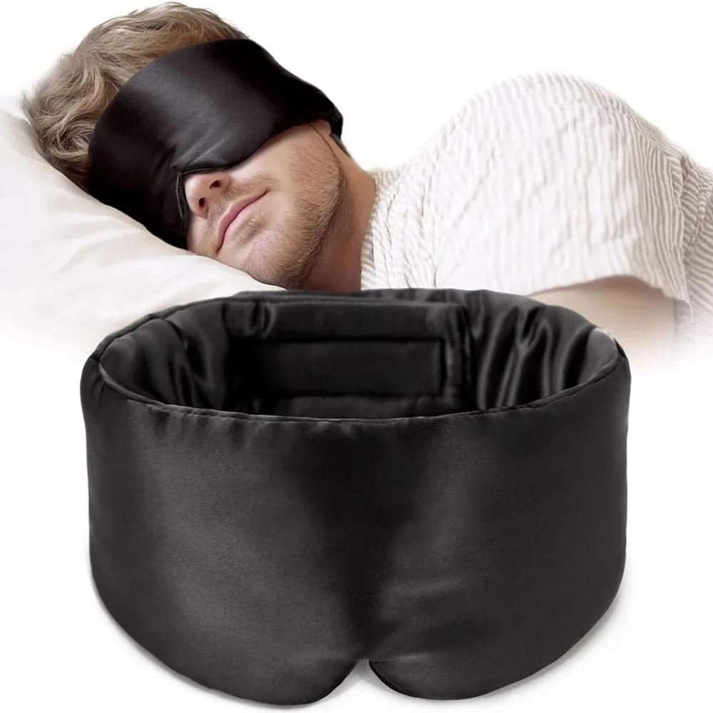 Person sleeping with a silk black eye mask and U-shaped pillow on a white background