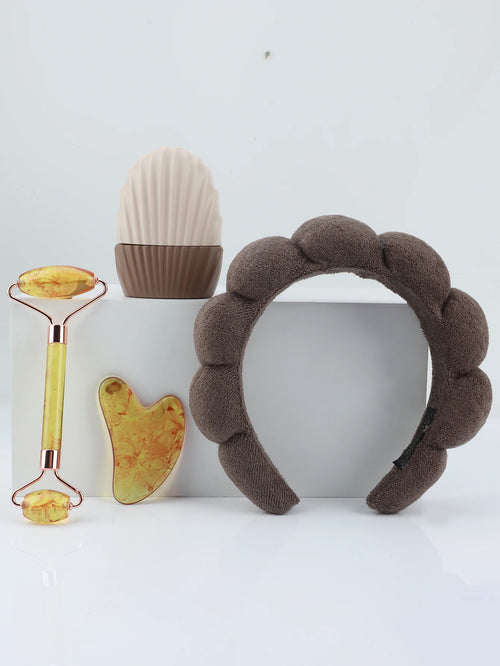 Brown textured headband with skincare tools on a white background