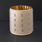 Decorative hair roller with gold interior and textured exterior on a black background