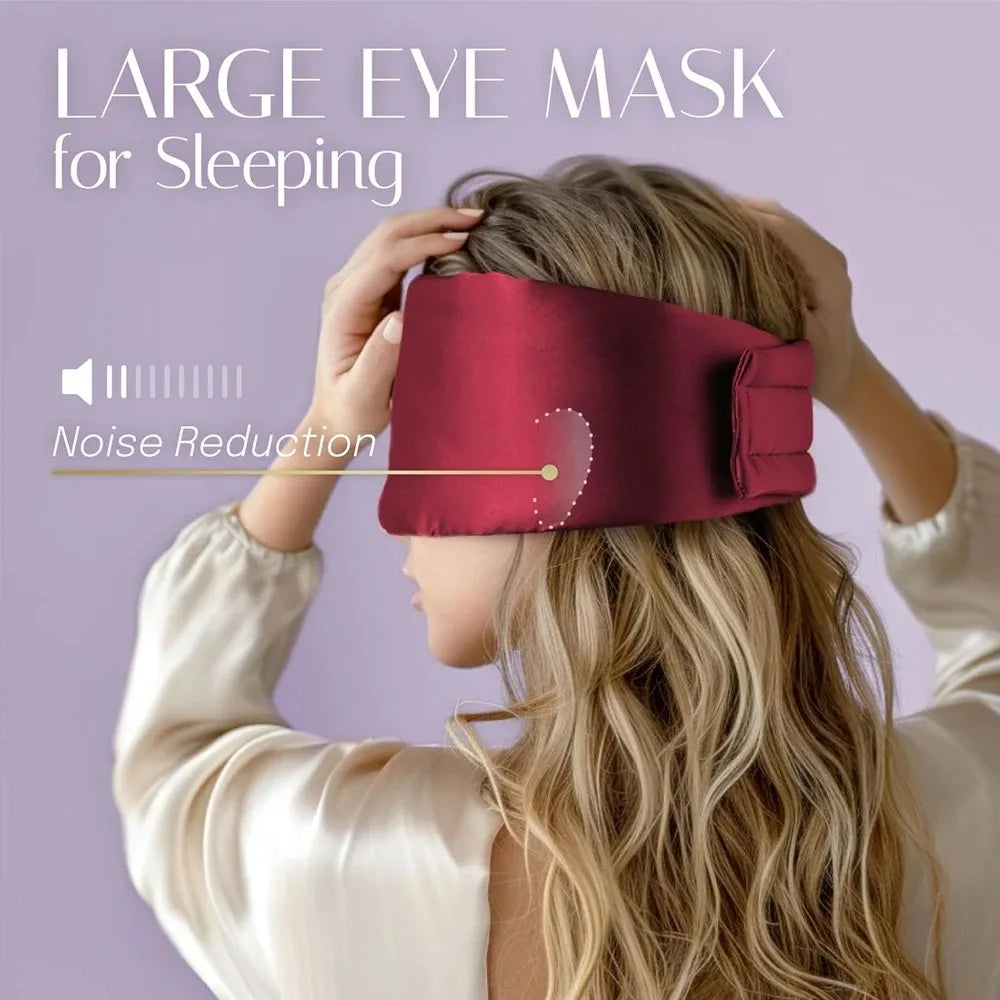 Person wearing a large silk eye mask for sleeping with noise reduction feature on a purple background