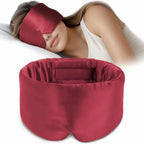 Person wearing a silk red sleep mask with a matching pillow on a white background