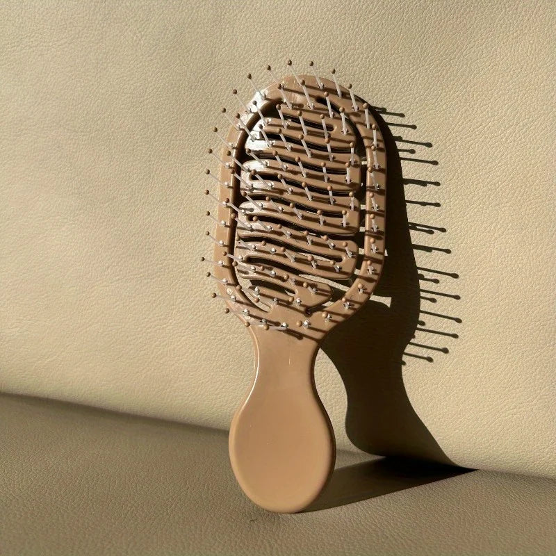 Beige hairbrush on a beige background. Mini Travel Hair Brush 