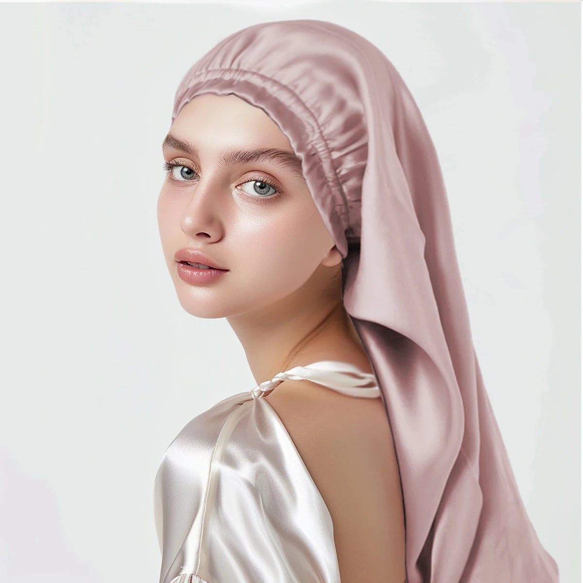 Woman wearing a pink pure mulberry silk bonnet headscarf on a white background