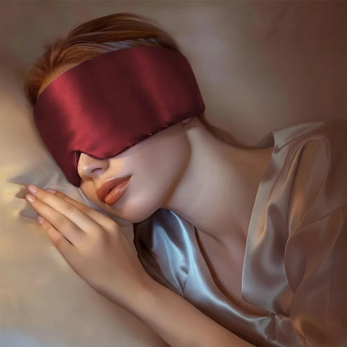 Woman wearing a mulberry silk red eye mask with skincare benefits highlighted on a beige background