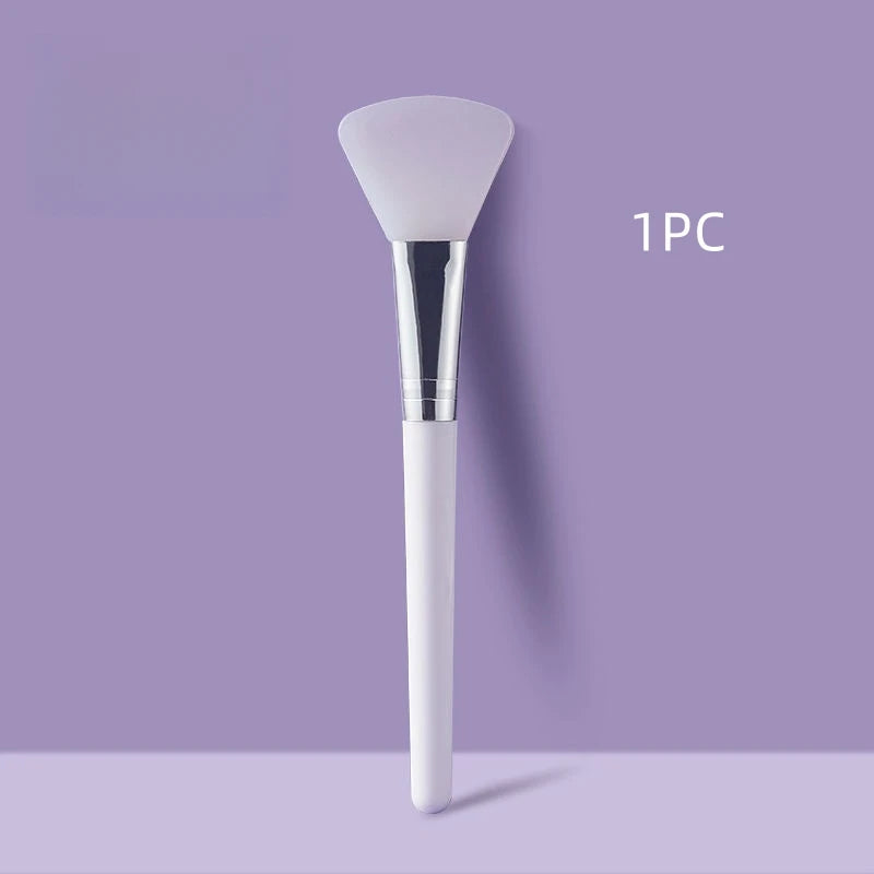 White facial mask brush with silver ferrule on a purple background
